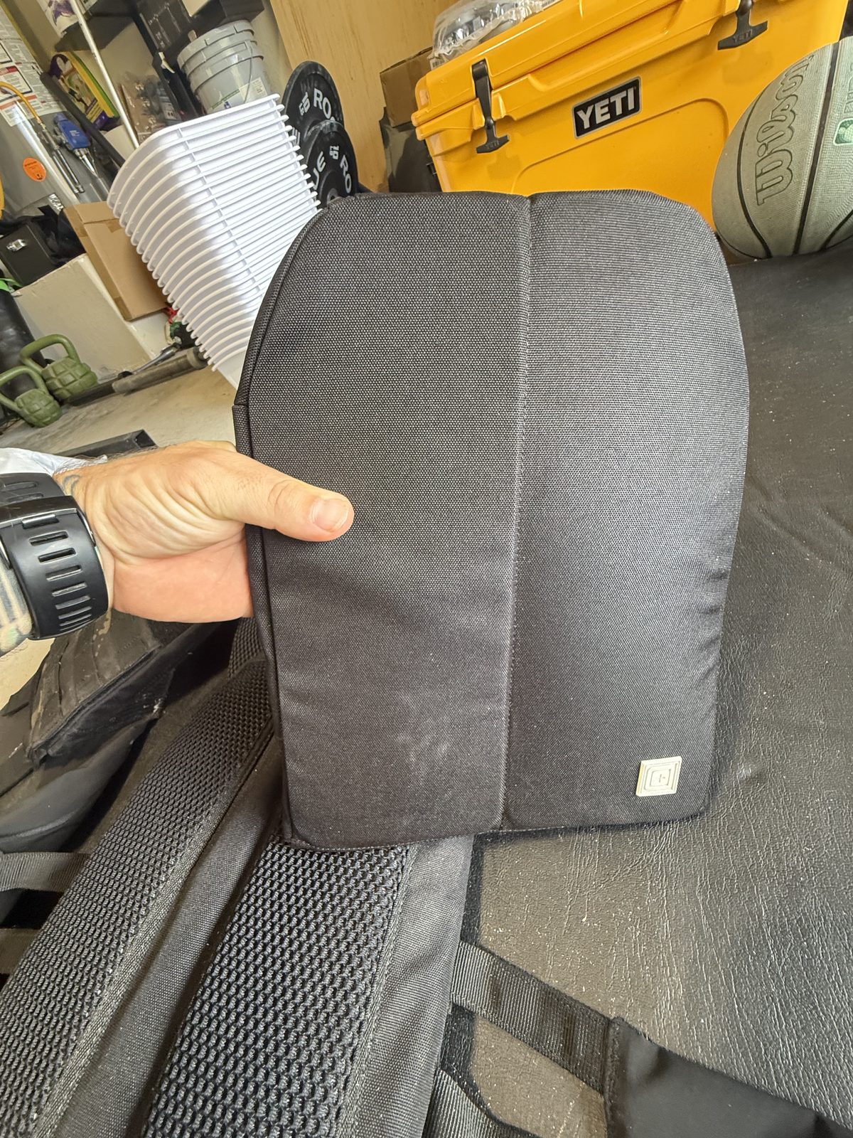 Holding one of the sand-filled weight plates for the TacTec Trainer