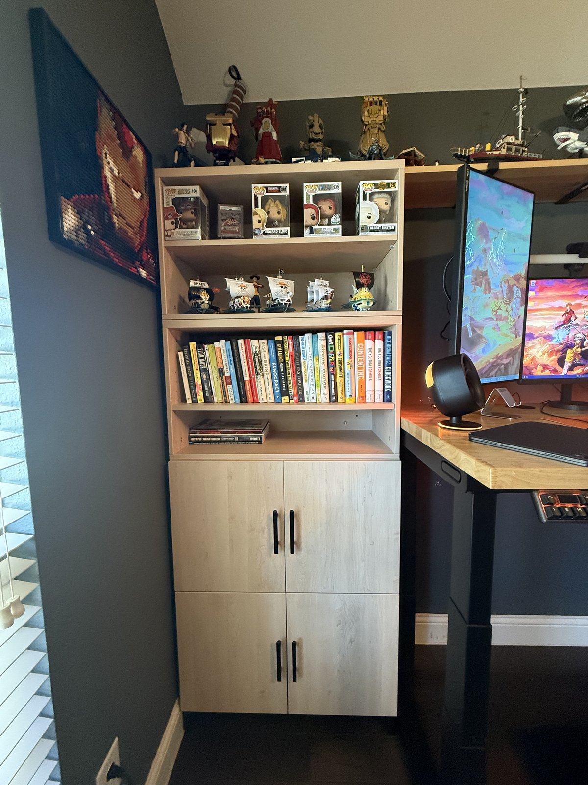 Four MoPac cabinets stacked beside my desk: two closed cabinets on the bottom, two open cabinets full of books and One Piece ships on top