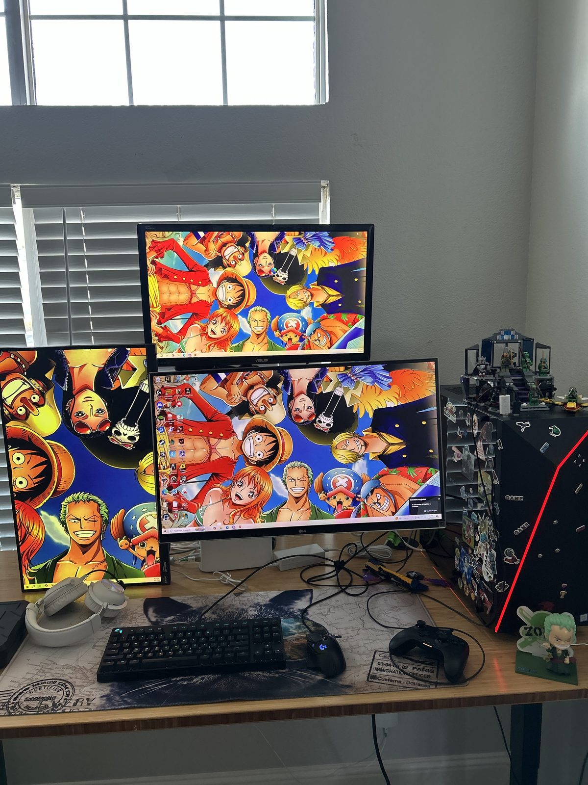 My old V3 set up at my best friend's house with three monitors showing One Piece