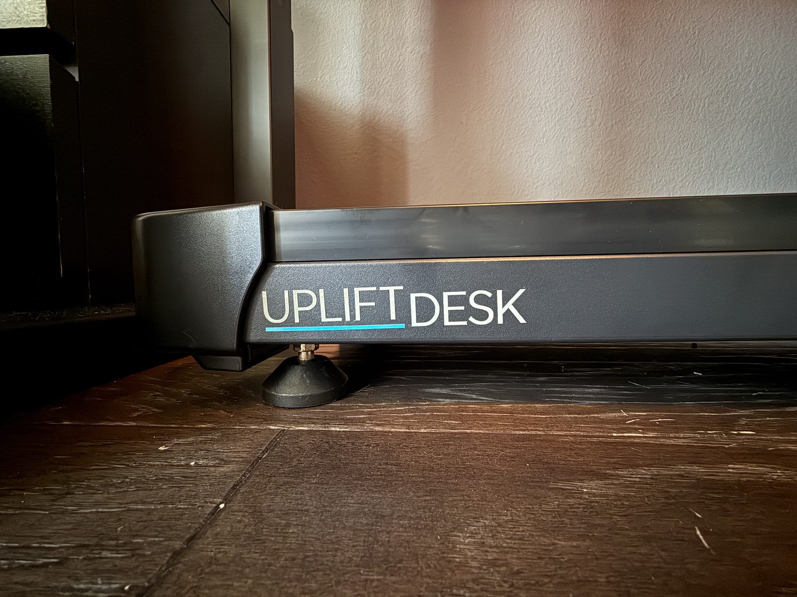 The UPLIFT DESK badge on the side of the walking pad