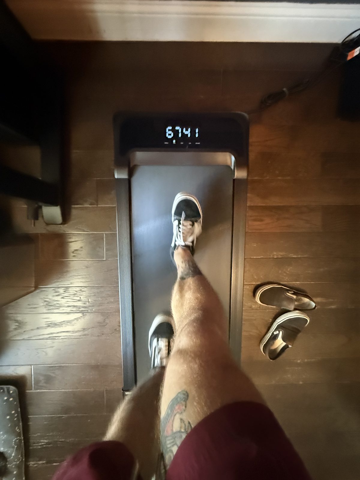 Looking down at the walking pad display mid walk, timer over an hour